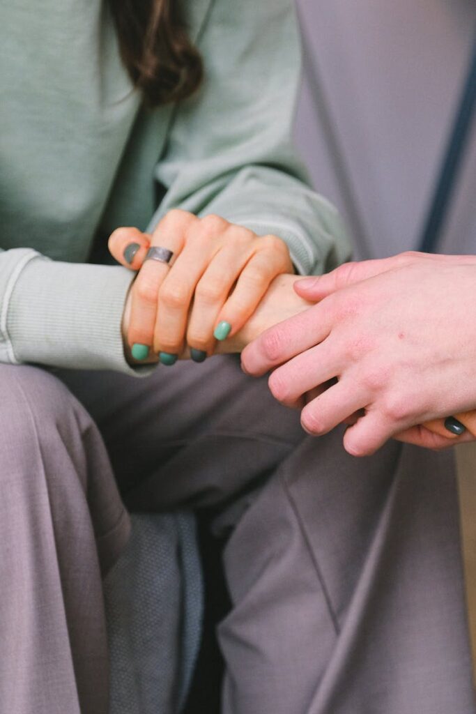 pexels-photo-7176325-7176325 Close-up of two people holding hands during a comforting therapy session.