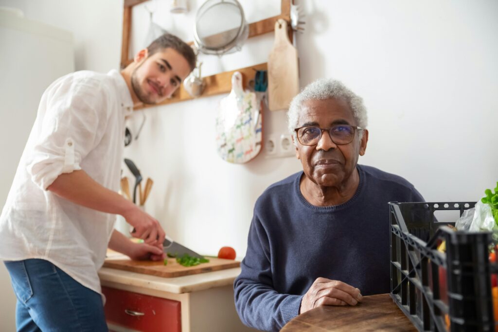 pexels-photo-7551592-7551592 A young adult helping a senior in the kitchen, highlighting care and support at home.